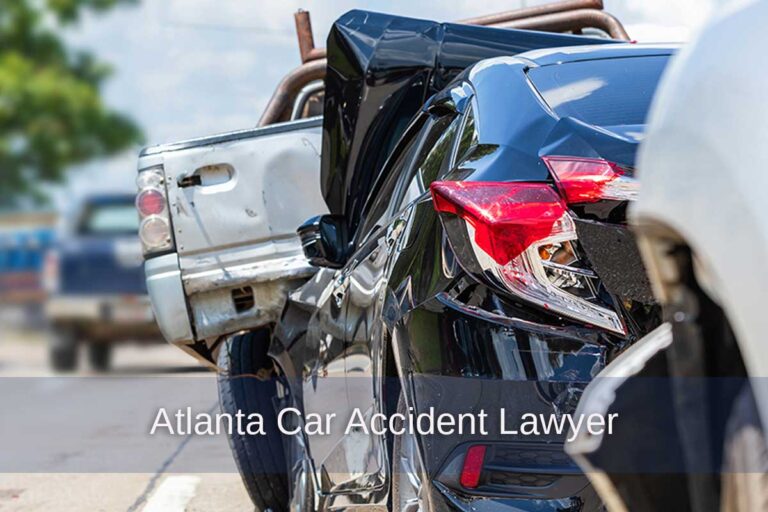 Auto accident involving a blue sedan and white truck on a road highlights the need for legal assistance from an Atlanta car accident lawyer.