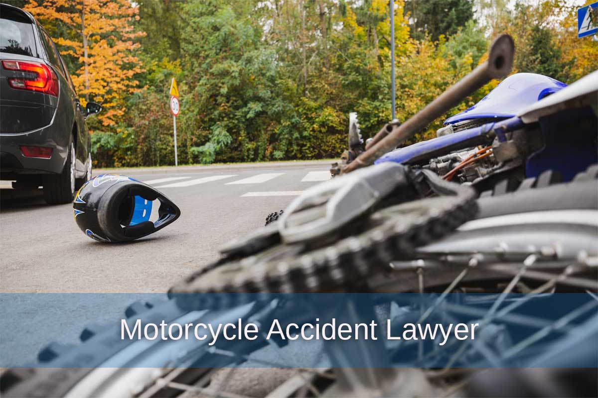 A motorcycle lies on the ground beside a car, illustrating the aftermath of an accident, relevant for motorcycle accident legal cases.