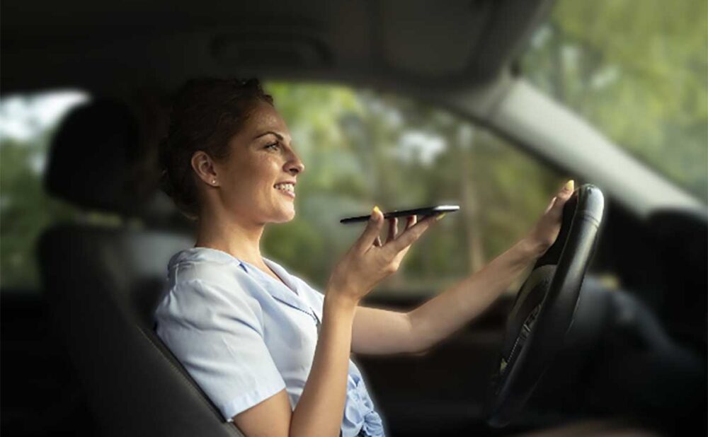 A woman driving while illegally holding a cell phone, highlighting some of the unique driving laws in Georgia.