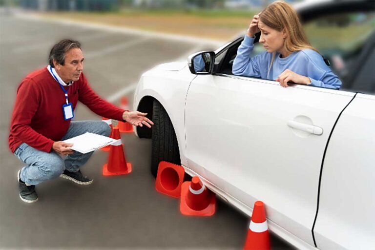 A young girl in a white car runs over cones during a driver's exam as the instructor watches on.