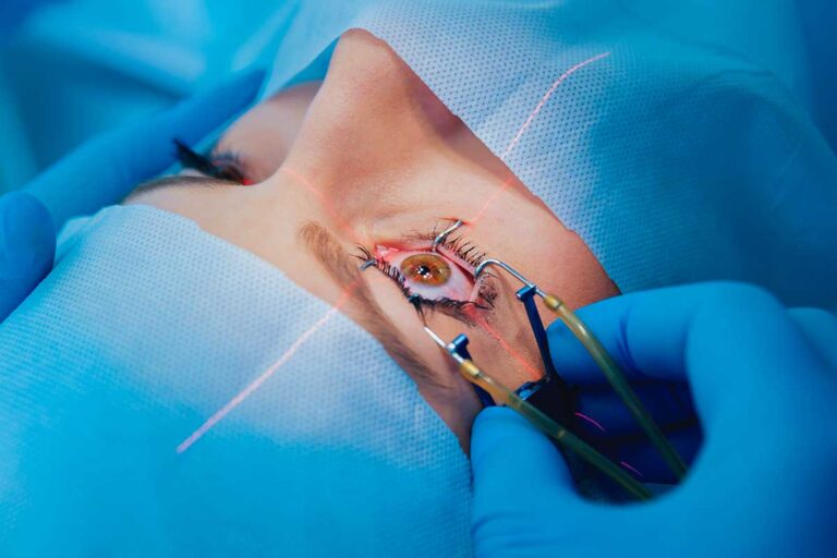 A patient undergoing eye surgery, with medical staff focused on the procedure in a sterile environment.