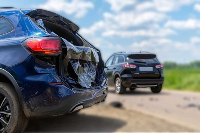 A blue SUV with visible damage from a rear-end collison.