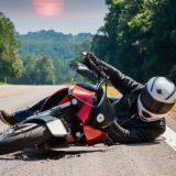 A person lies on the ground beside a motorcycle, illustrating the risks of common motorcycle accident injuries in Georgia.