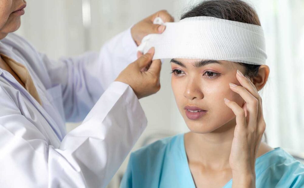 A woman with a bandaged head, representing common car accident injuries.