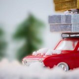 A red vehicle topped with numerous boxes, representing the importance of holiday safety and accident prevention.