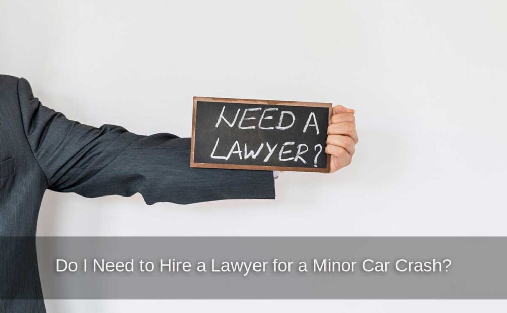 A man holding a sign contemplates whether to hire a lawyer after a minor car crash.