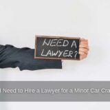 A man holding a sign contemplates whether to hire a lawyer after a minor car crash.