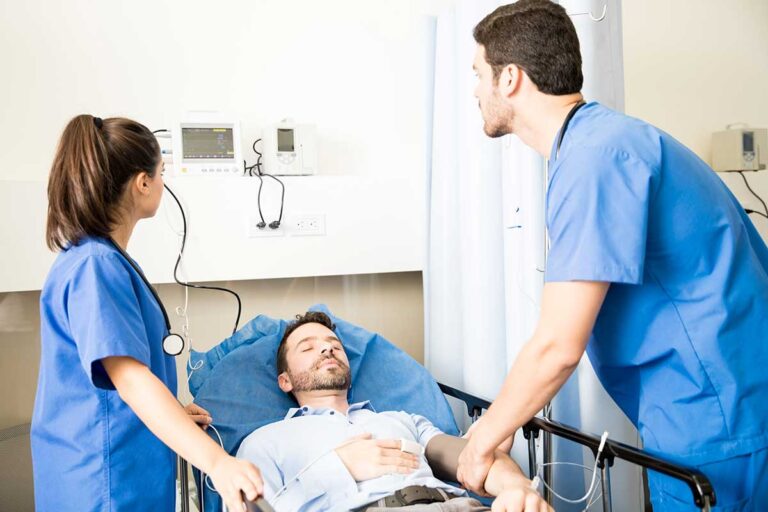 Medical professionals examine a patient in a hospital bed, underscoring the importance of immediate medical care after a car accident.