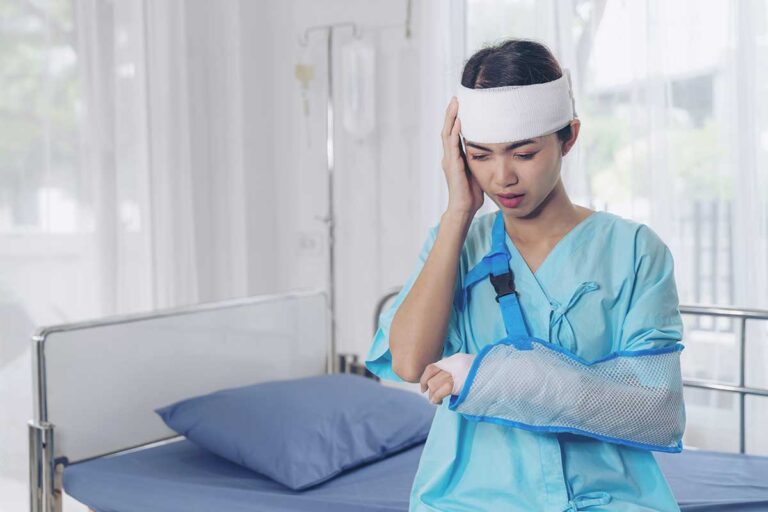 A woman in a hospital room with an arm cast and head trauma, symbolizing the impact of catastrophic injuries in Georgia.