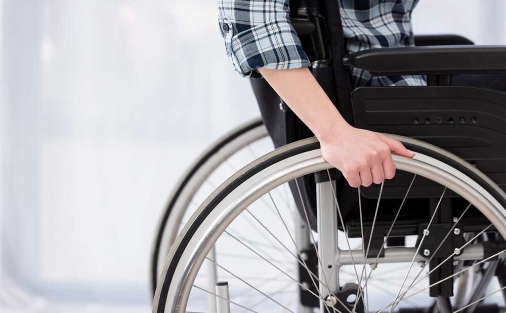 A person in a wheelchair confidently grips the wheel, symbolizing resilience in the face of catastrophic injuries in Georgia.