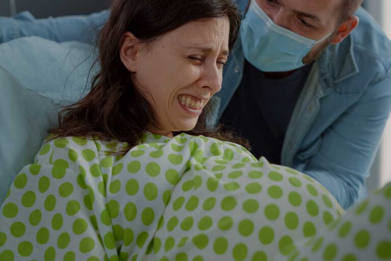 A pregnant woman and a man in the delivery room, highlighting the serious context of medical malpractice and privacy issues in Georgia.