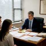 Attorney consulting couple in law office about train accident