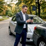 Driver documenting car accident scene