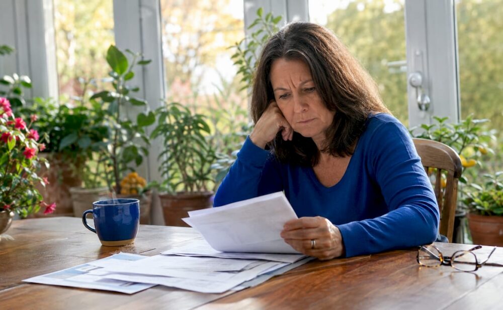 Woman reviewing injury documents at kitchen table