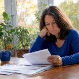 Woman reviewing injury documents at kitchen table