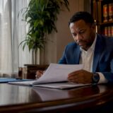 Man reviewing injury settlement documents in office