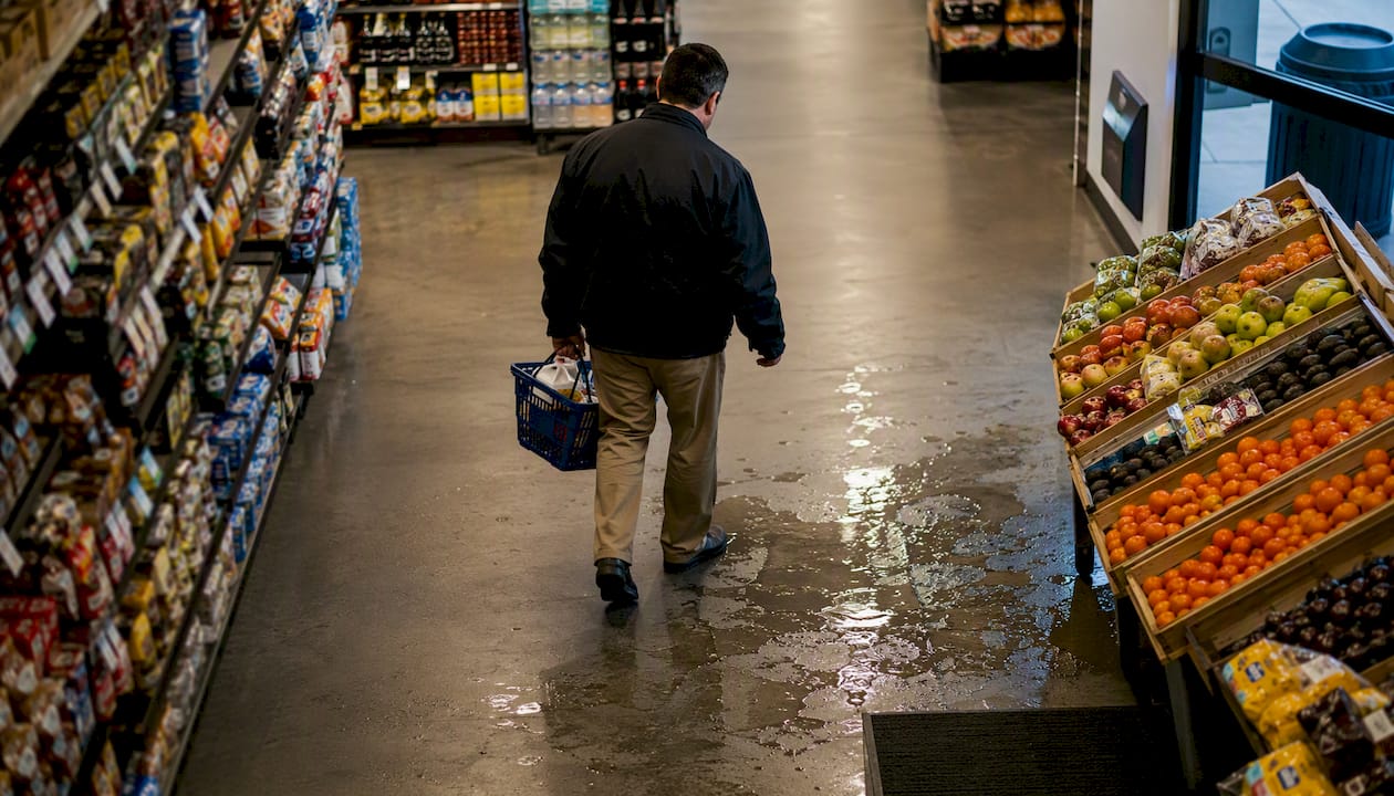Wet floor with tipped caution sign in grocery store