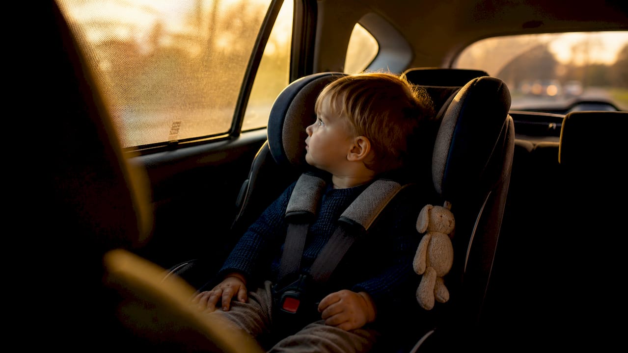 Child safely buckled in car seat inside car
