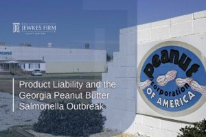 Peanut Corporation of America sign in front of a factory building, representing the Georgia peanut butter salmonella outbreak and related product liability issues.