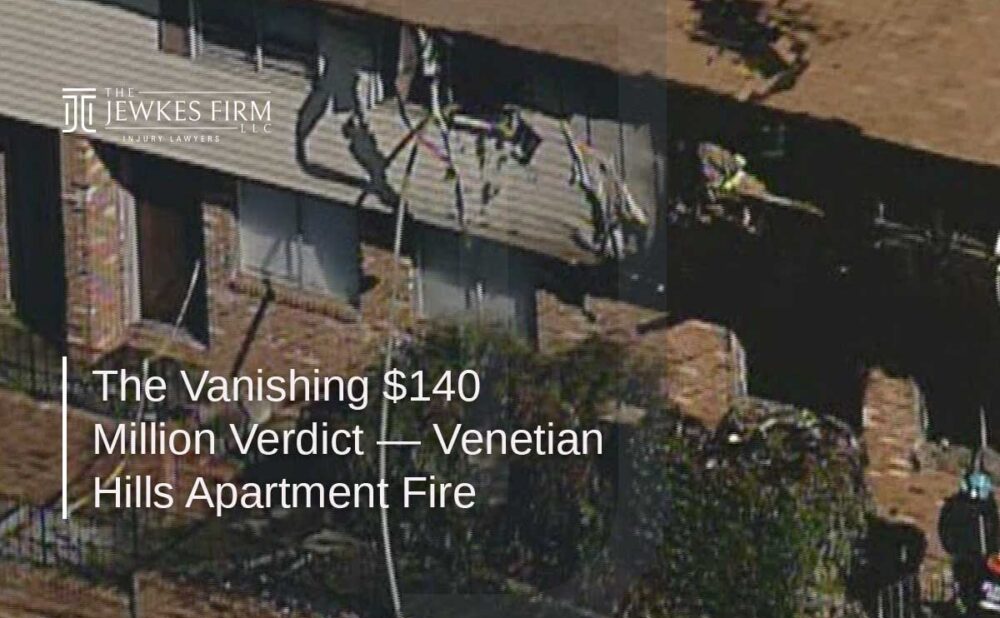 Burned apartment building with a heavily damaged roof and shattered windows following a fire, showing the aftermath of the Venetian Hills apartment fire.